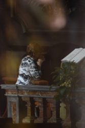 Personne agenouillée dans la pénombre d'une église