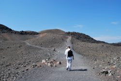 homme marchant sur le Kameni de Santorin